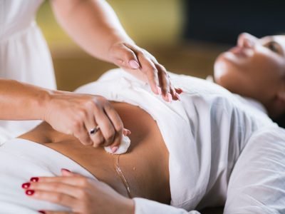Spiritual Healer Using Cotton Balls and Water for Philippine Psychic Surgery Treatment Philippine Psychic Surgery Healer Using Cotton Balls and Water for Treatment. Female Patient Laying on Back.